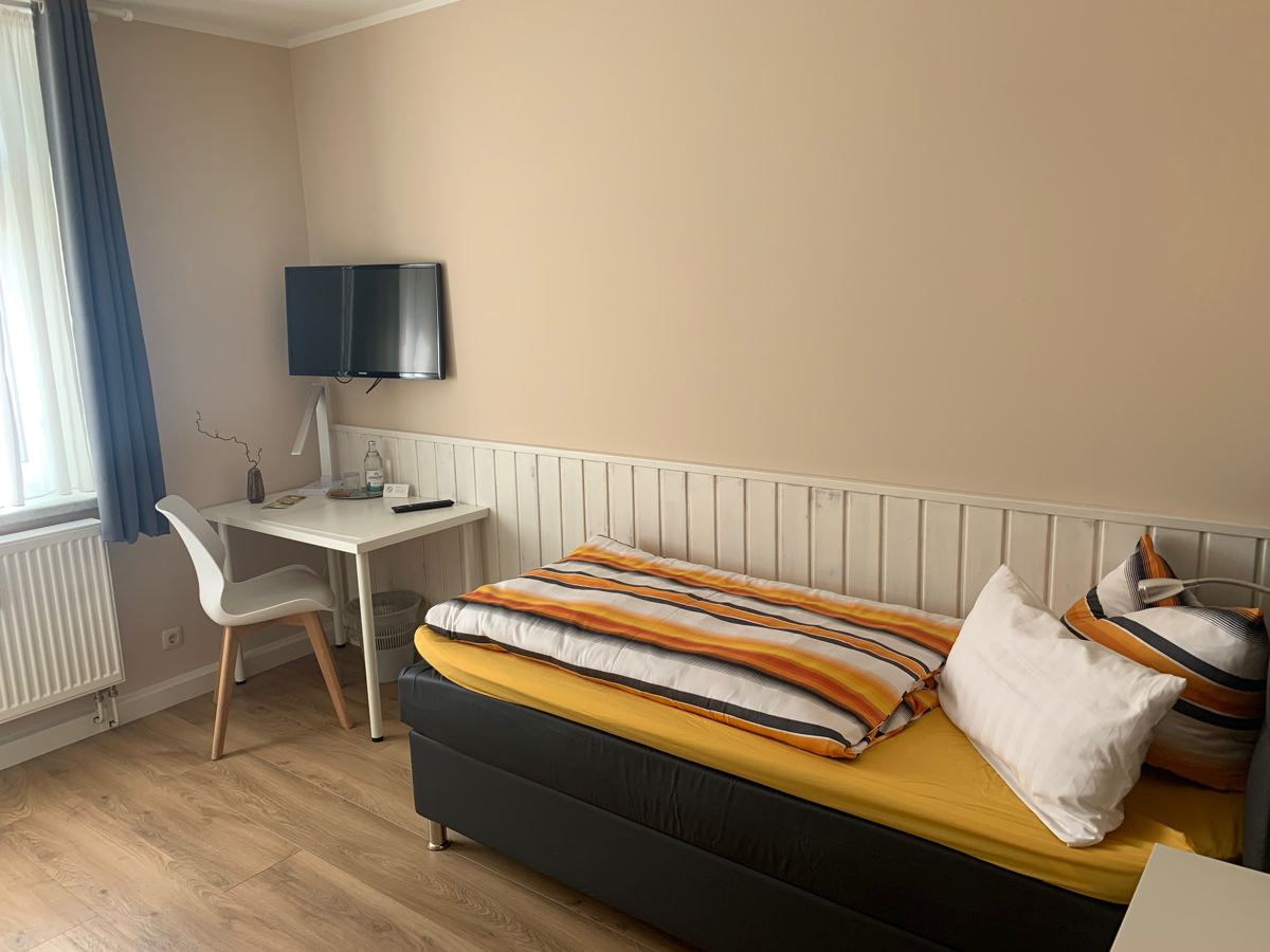Single room with bed, desk and TV